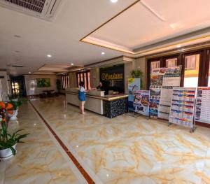 a woman standing at a counter in a hotel lobby at Vang Vieng Consiana Hotel in Vang Vieng