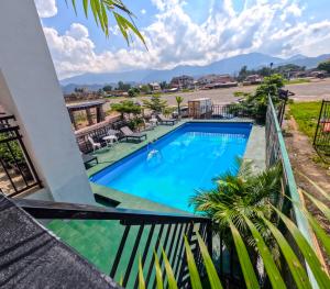 Vom Balkon eines Resorts genießen Sie Poolblick. in der Unterkunft Vang Vieng Consiana Hotel in Vang Vieng