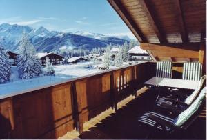 balcón con 2 sillas y vistas a una montaña nevada en Ferienwohnungen LANG - Ski & Mountain Apartments, en Königsleiten