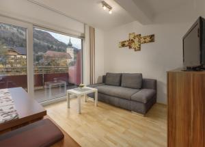a living room with a couch and a large window at Appartementhaus Crystal by Schladming-Appartements in Schladming