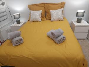 Un dormitorio con una cama amarilla con toallas. en PORTE DE FRANCE en Estrasburgo
