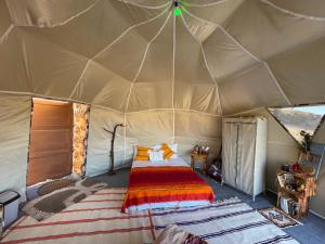 a bedroom in a tent with a bed in it at Eagles Dôme in Bou Tferda