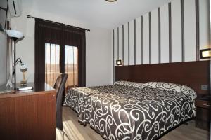 a bedroom with a bed and a dresser and a desk at Hotel Ciudad de Plasencia in Plasencia +37 photos