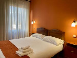イーゾラ・デル・リーリにあるMingone Hotel Ristoranteのベッドルーム1室(ベッド1台、タオル2枚付)