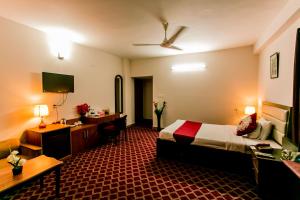 Habitación de hotel con cama y escritorio en GR MEET & GREET en Dhaka