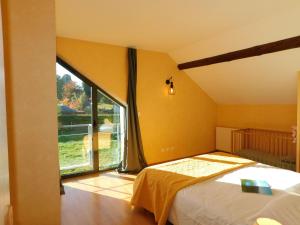 a bedroom with a bed and a large window at Gites et Cocon des Puys in Nébouzat