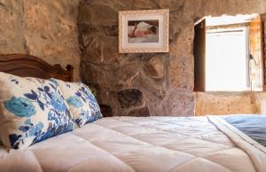 a bedroom with a bed in a stone wall at Casa Moinho da Mouta in Parada de Pinhão +82 photos