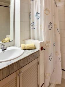 a bathroom with a sink and a shower curtain at Apartment mit Traumblick in Sóller