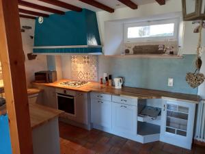 a kitchen with white cabinets and a blue counter top at Gites et Cocon des Puys in Nébouzat