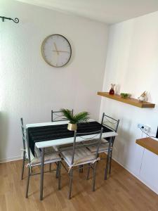 a dining room table and chairs with a clock on the wall at Wohnung VS 3 in Villingen-Schwenningen