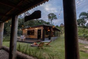 a log cabin with a fire pit in the yard at Cabana com Ofurô e Cinema a 6km do Centro in Ibicaré