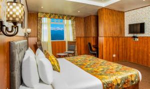 a hotel room with a bed and a television at Summit Oakden Resort & Spa in Darjeeling