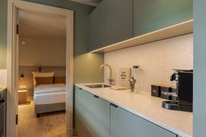 a kitchen with a sink and a bed in a room at SeaSide LOFTS im Herzen von Westerland in Westerland (Sylt)
