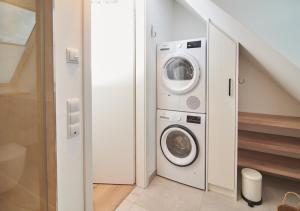 uma lavandaria com máquina de lavar e secar roupa em Sunshine Suite - mit Meerblick em Timmendorfer Strand