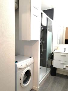 uma casa de banho com uma máquina de lavar roupa e um lavatório em A Deux Pas des Halles - Hypercentre - Idéal Couple em Pau
