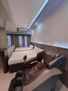 a bedroom with two beds and a couch in it at Mall of Asia_Pasay Condotel with Massage Chair and PS4- Stellar Suites in Manila
