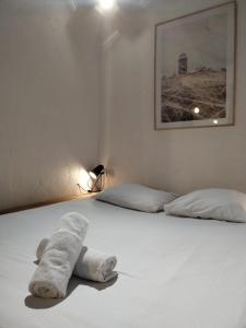 een wit bed met twee handdoeken erop bij A Deux Pas des Halles - Hypercentre - Idéal Couple in Pau