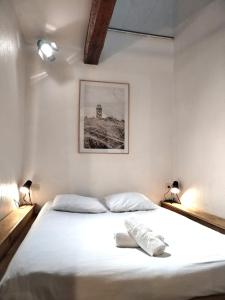 波城的住宿－A Deux Pas des Halles - Hypercentre - Idéal Couple，一间卧室配有一张带两盏灯的大型白色床。