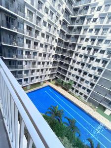 a balcony view of a large apartment building with a swimming pool at Mall of Asia_Pasay Condotel with Massage Chair and PS4- Stellar Suites in Manila