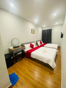 a bedroom with a bed and a desk with a mirror at Phú Gia 464 NVL in Ho Chi Minh City