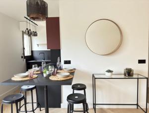 kuchnia ze stołem ze stołami i lustrem w obiekcie Charmant Appartement Neuilly - 10mn Champs-Elysées w mieście Neuilly-sur-Seine