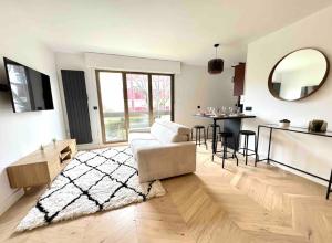a living room with a couch and a table at Charmant Appartement Neuilly - 10mn Champs-Elysées in Neuilly-sur-Seine