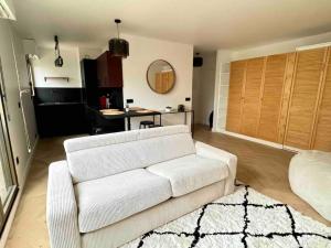 a living room with a white couch and a table at Charmant Appartement Neuilly - 10mn Champs-Elysées in Neuilly-sur-Seine