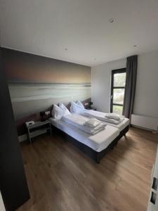een slaapkamer met een groot bed en een raam bij Chalet Sunrise Vierte Reihe Haus Nr 218 in Enkhuizen