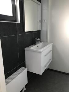 een witte badkamer met een wastafel en een spiegel bij Chalet Sonnenplätzchen Zweite Reihe Haus Nr 229 in Enkhuizen