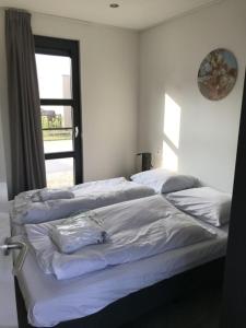 een slaapkamer met 2 bedden en een raam bij Chalet Sonnenplätzchen Zweite Reihe Haus Nr 229 in Enkhuizen