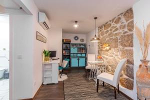 a living room with a stone wall and a table and chairs at Apartments Mikulin Family in Punat