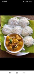 a plate of food with rice and a bowl of curry at Estate villa homestay in Mudigere