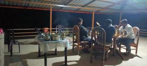a group of people sitting at a table in a tent at Estate villa homestay in Mudigere