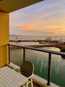 a balcony with a bench and a view of a marina at Serenity Peary - Executive 1brm at Darwin Waterfront with Sea Views in Darwin