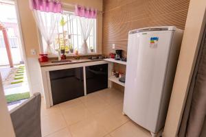 uma cozinha com um frigorífico branco e uma janela em Otimo flat a 750m do mar Sta Monica Guarapari ES em Guarapari