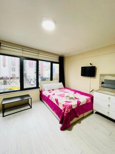 Schlafzimmer mit einem Bett, einem TV und Fenstern in der Unterkunft Apart 71 in Istanbul