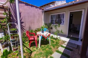 een tafel en stoelen in de tuin van een huis bij Otimo flat a 750m do mar Sta Monica Guarapari ES in Guarapari