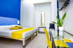 a bedroom with a bed and a yellow chair at V10 GUESTHOUSE - Vanvitelli 10 in Naples