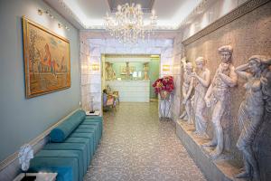 un pasillo con un mural de mujeres en la pared en Parthenon Art Hotel en Olympiakí Aktí