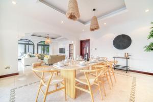 a dining room and living room with a table and chairs at Frond D Villa, Palm Jumeirah - Mint Stay in Dubai