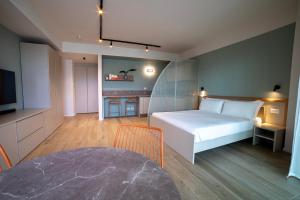 ein Schlafzimmer mit einem weißen Bett und einem Fernseher in der Unterkunft Be Mate Torino Centro in Turin