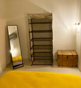 uma sala de vestir com uma cama amarela e um espelho em Superbe 2 pièces TERRASSE / PISCINE / VUE / PARKING em Nice