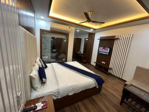 a bedroom with a bed with a ceiling fan at Hotel The Rich Grand Agra in Agra
