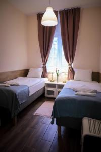 a bedroom with two beds and a window at East Station Comfort Plus in Budapest