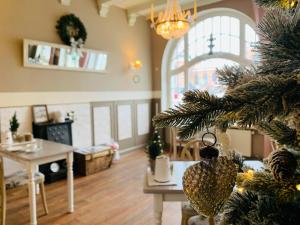 un arbre de Noël dans une pièce avec un salon dans l'établissement Zum weißen Haus, à Schwerin