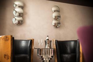 a dining room with black chairs and lights on the wall at Liassidi Wellness Suites in Venice