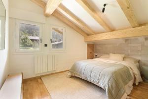 sypialnia z łóżkiem i dwoma oknami w obiekcie Chalet Béchar Le Magnifique- Garden - Sauna & Jacuzzi w mieście Les Bossons