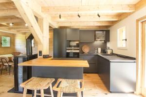 kuchnia z blatem i krzesłami w pokoju w obiekcie Chalet Béchar Le Magnifique- Garden - Sauna & Jacuzzi w mieście Les Bossons