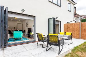 un patio con sillas y un sofá en Stunning West London W7 Modern Huge place 4bed 2 bath with garden free parking (7 occupancy), en Londres
