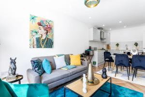 a living room with a couch and a kitchen at Stunning West London W7 Modern Huge place 4bed 2 bath with garden free parking (7 occupancy) in London